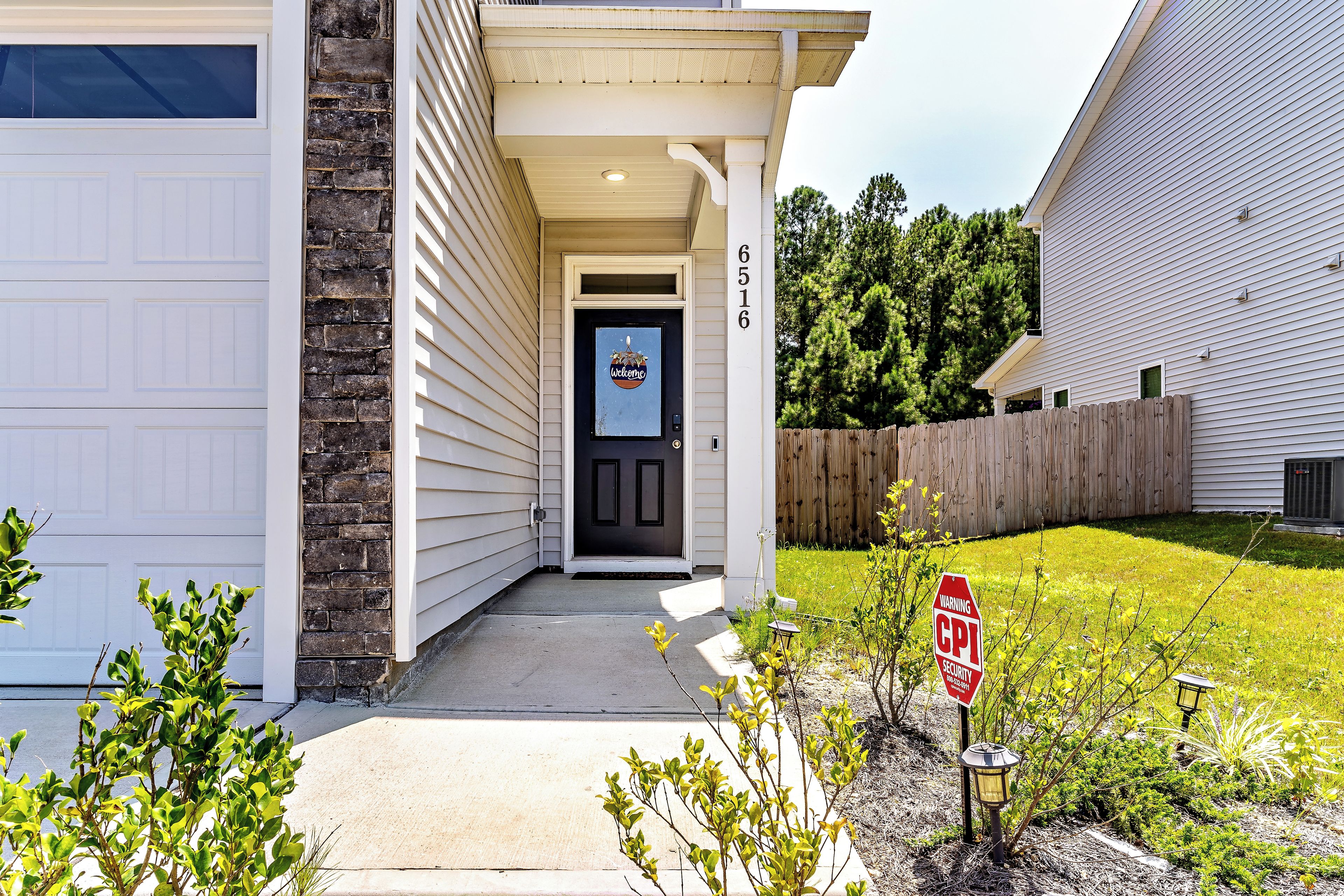 A residential house with a front door, a garage, and a number 6516 on the wall.