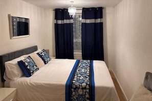 A bedroom with a bed, a nightstand, a mirror, and a chandelier. - Streatham / Tooting 1 Bed Apartment Off Street Parking, Wifi & Great Transport Links Sleeps 4 (London)