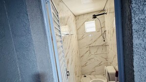 A bathroom with a toilet, a sink, and a shower area. - Perfect com piscina e 3-bedroom house in Peruíbe for a relaxing getaway (Peruíbe)