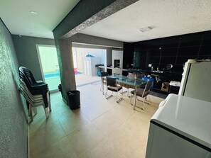 A modern kitchen with a dining area, a trash bin, and a view of the outside.