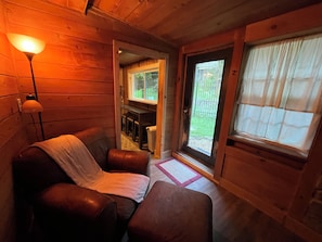 Um quarto aconchegante com um sofá de couro, uma mesinha e uma luminária.