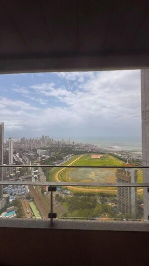 A high-rise building with a view of a cityscape and a sports field.