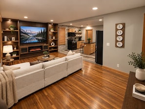 A modern living room with a large flat-screen TV, a fireplace, and a cozy sofa. - Enjoyable 3-bedroom house with AC in charming Nashville (Nashville)