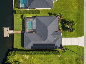 A residential property with a swimming pool, a covered patio, and a well-maintained lawn. - Turtle Cove | Heated Pool & Waterfront Retreat (Cape Coral)