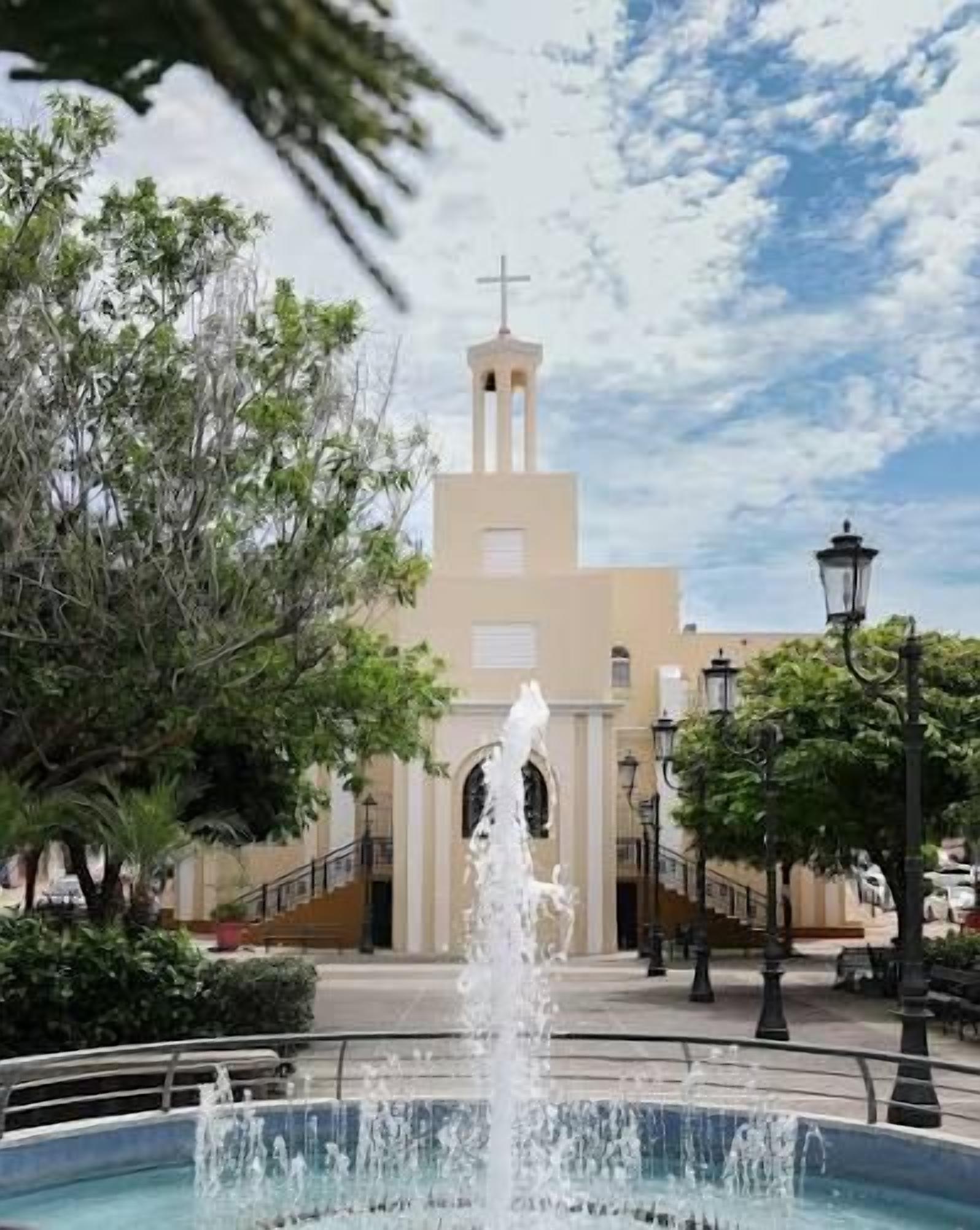 Una fuente en primer plano y una iglesia al fondo.