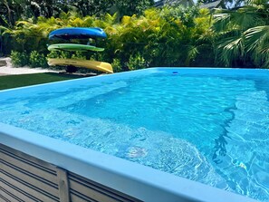 A clear blue swimming pool with a wooden deck edge. - Riverfront Retreat- Heated POOL- Heart of Tampa (Tampa)