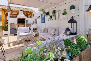 An outdoor patio with a barbecue area, seating, and potted plants. - Luxury Villa Costabella Marbella—Pool, Jacuzzi, and Sauna—400 m from the Beach (Marbella)