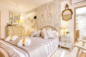 A hotel room with a large bed, a vanity with a mirror, and a dresser. - Luxury Villa Costabella Marbella—Pool, Jacuzzi, and Sauna—400 m from the Beach (Marbella)