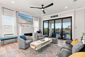 A modern living room with a fireplace, seating area, and a view of the outdoors.