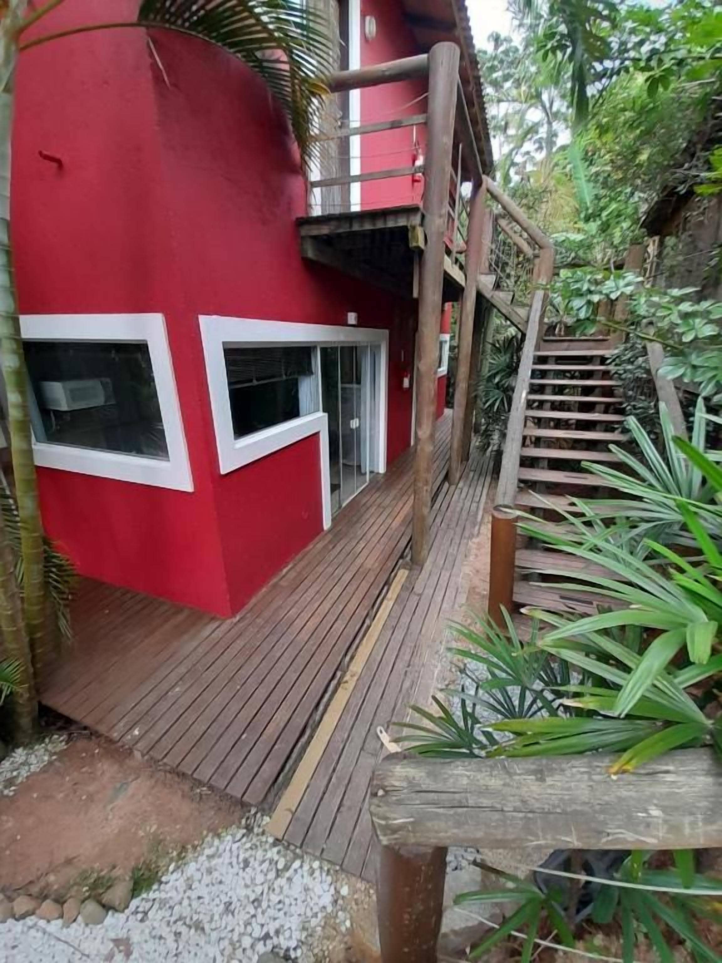 Un edificio rojo con una escalera de madera que lleva a un balcón.