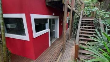 Un edificio rojo con una escalera de madera que lleva a un balcón.