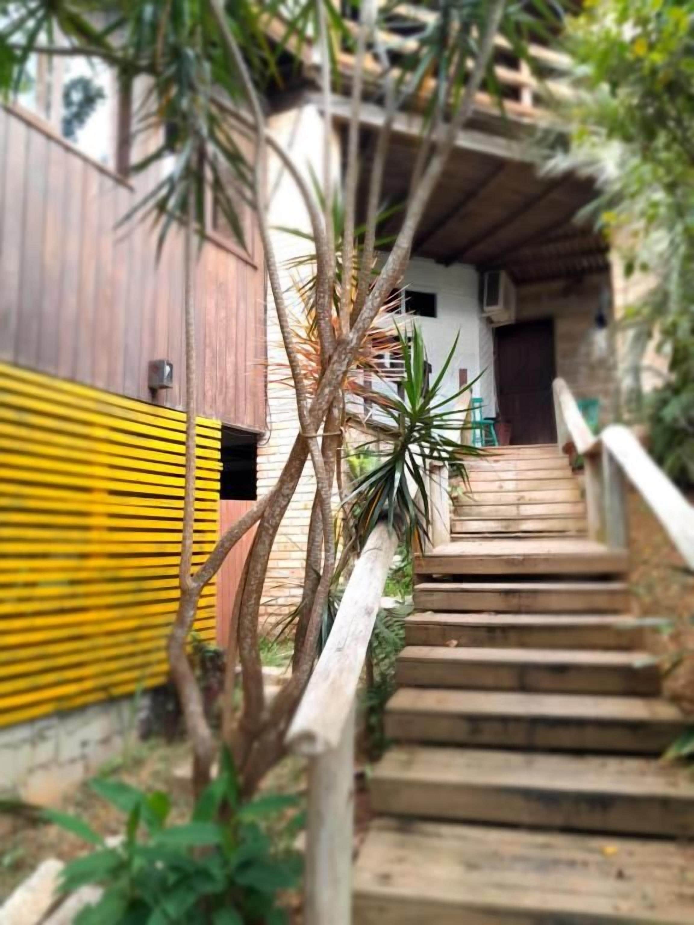 Una escalera de madera que lleva a un edificio con una cerca amarilla y negra a la izquierda.