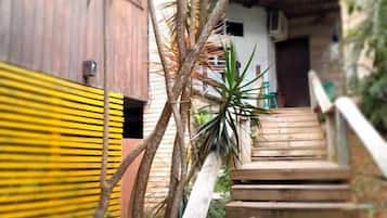 Una escalera de madera que lleva a un edificio con una cerca amarilla y negra a la izquierda.