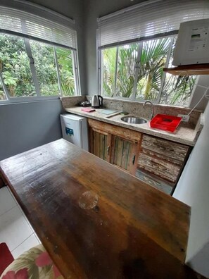 Eine kleine Küche mit Holztischplatte, Spüle und einem Kühlschrank.