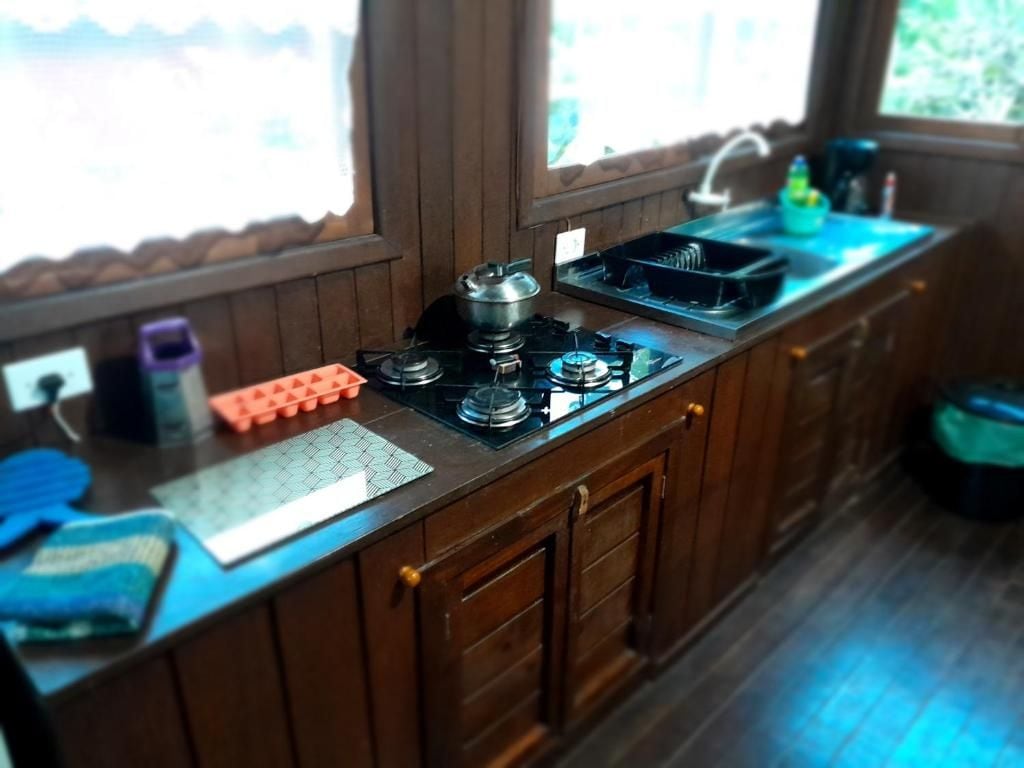 Una cocina con estufa a gas, un lavamanos y una ventana.