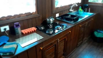 Una cocina con estufa a gas, un lavamanos y una ventana.