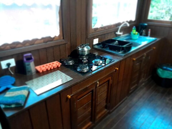 A kitchen with a gas stove, a sink, and a window.
