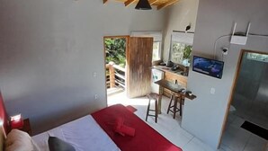 A bedroom with a bed, a red blanket, and a wooden ceiling. - Pousada Baia Rosa (Imbituba)