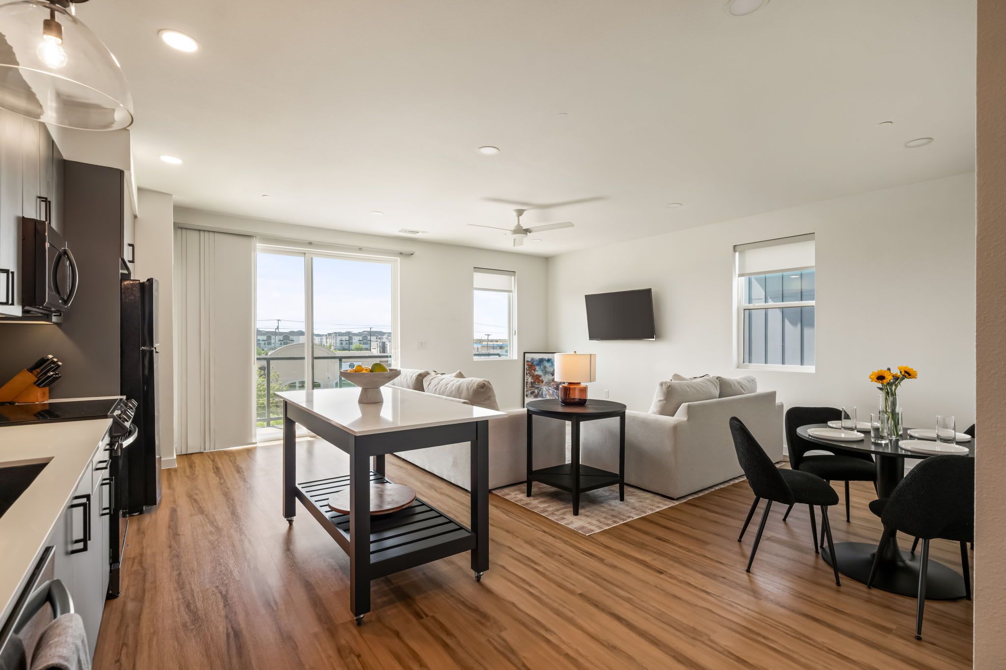A modern apartment with a kitchen, dining area, and living room.