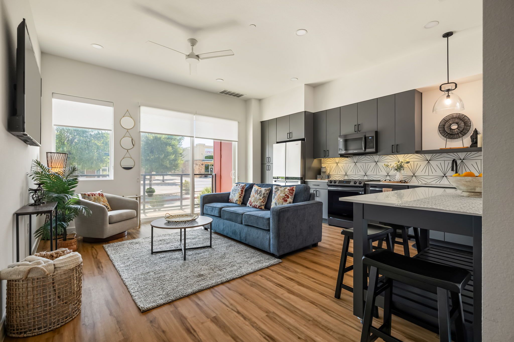 A modern living room with a sofa, coffee table, and a dining area with a kitchen in the background.