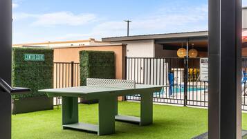 An outdoor area with a pool, a table, and a sign indicating 'Center Court'.