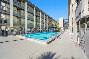 Un hôtel à plusieurs étages doté d’une piscine, d’un espace extérieur aménagé et de balcons.