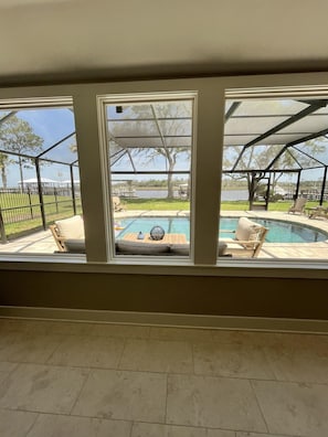A room with a view of a backyard patio area, including a swimming pool and outdoor furniture. - Spacious 3BR Home With Private Pool and Water Views in Yulee. Easy Access to Amelia Island (Yulee)