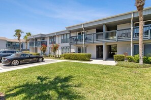 A multi-story residential building with balconies, a parking area, and well-maintained landscaping. - New Listing - 3BR Condo w/ Pool Walk to Beach (Fernandina Beach)