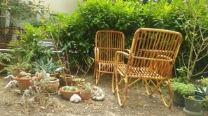 A garden with two wicker chairs, various potted plants, and a metal fence. - Two-bedroom apartment with garden, only 5 min walking to the Bacvice beach (Split)