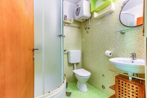 Een badkamer met toilet, wastafel en douche.