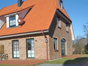 A brick building with a red-tiled roof, large windows, and a stone bench outside. - Holiday Home With 2 Bedrooms (St. Peter-Ording)