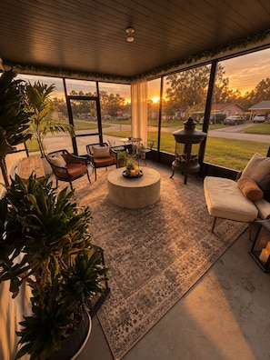 A sunlit patio with a round table, chairs, and a potted plant. - CASA CAMEO European-Inspired Tampa Stay (Tampa)