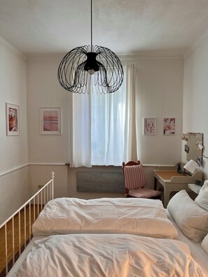 A bedroom with a bed, a chair, a desk, and a wall-mounted mirror. - Romantic vacation rental with bathrobes—right in the heart of downtown (Bamberg)