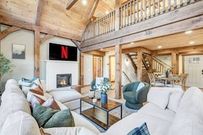 A spacious living room with a fireplace, a staircase, and a dining area. - New Build w/ Views, Hot Tub, & Sauna. Sleeps 16 (Massanutten)