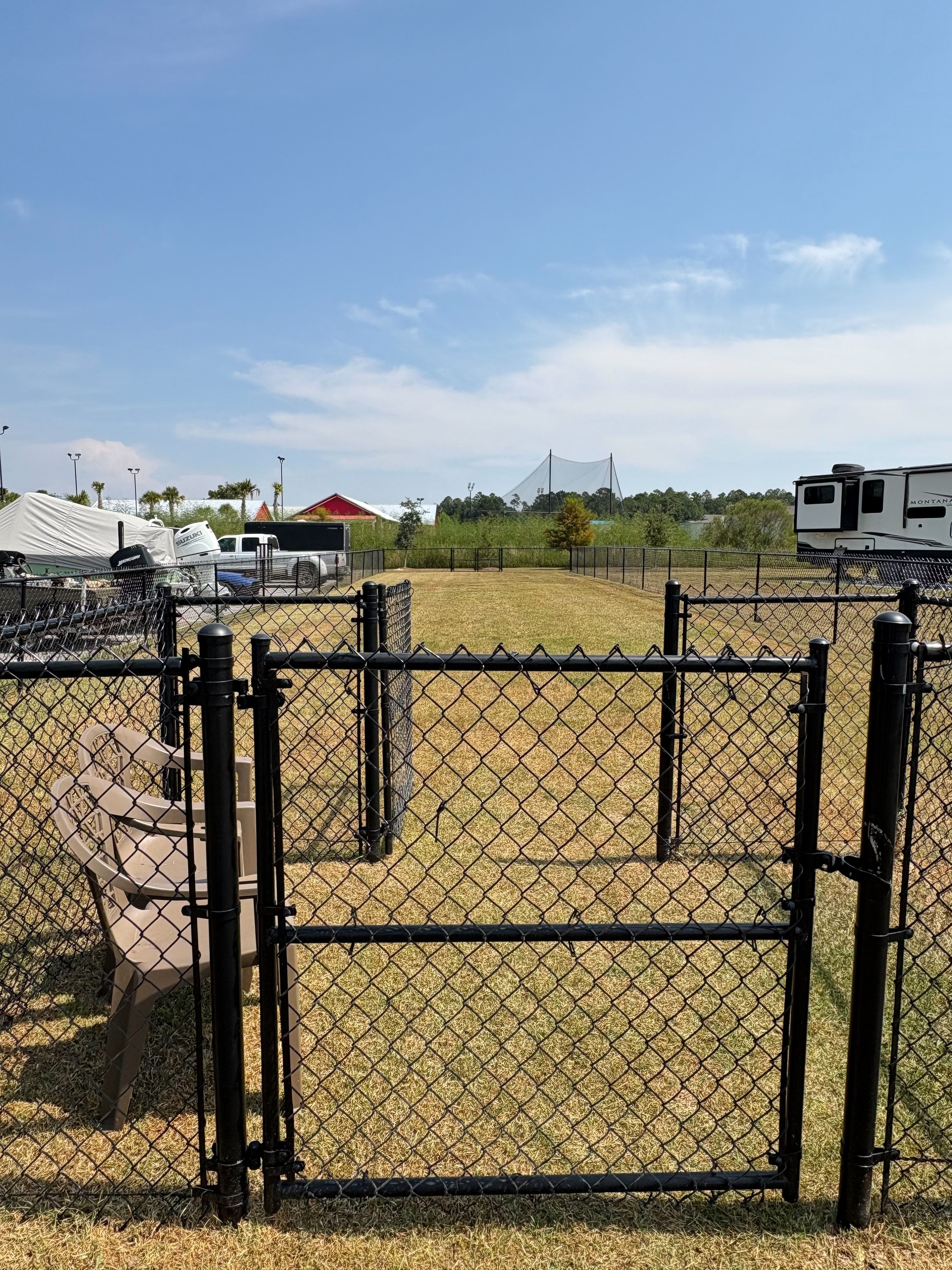 A fenced area with a tent and a vehicle, likely a campsite.