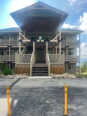 A multi-story building with a wooden exterior, a central staircase, and a balcony on the upper floor. - Cozy 3-bed mtn condo in village, walkable to all! (Slaty Fork)