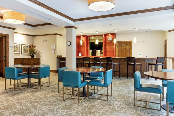 A hotel lobby with multiple seating areas, including round tables and chairs, a bar area, and a reception desk. - Ascent Condo 310 | 3BR Downtown Avon Condo, Sleeps 6, Indoor Pool (Beaver Creek)