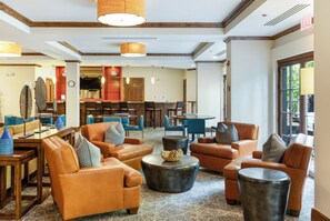 A hotel lobby with leather sofas, a coffee table, and a dining area with blue chairs. - Ascent Condo 310 | 3BR Downtown Avon Condo, Sleeps 6, Indoor Pool (Beaver Creek)