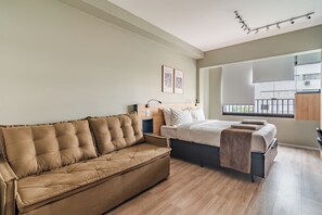 Ett modernt sovrum med en soffa, en säng och ett fönster med utsikt.