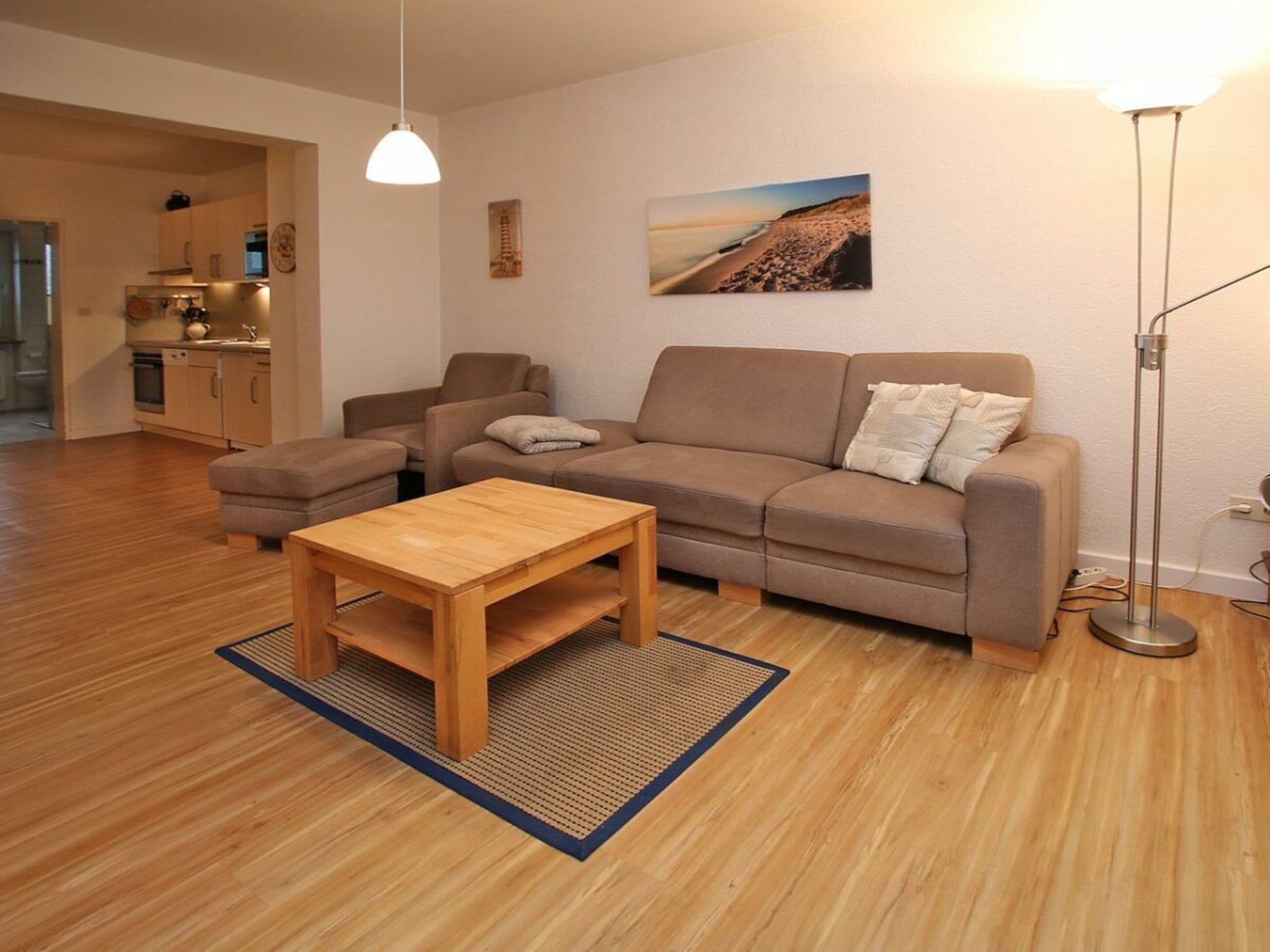 Een moderne woonkamer met een bank, een bijzettafeltje en een schilderij aan de muur.
