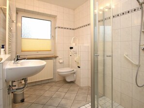 A bathroom with a sink, toilet, and shower. - Flurstrasse 10, Holiday Apartment 1 (Wyk auf Foehr)