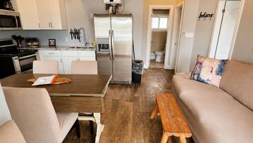 A compact living space with a kitchenette, a dining area, and a seating area.
