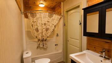 A bathroom with a toilet, bathtub, and sink.