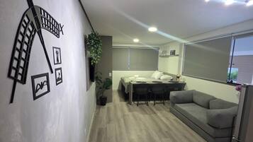 Um interior moderno com um sofá, uma mesa de jantar e uma cama.
