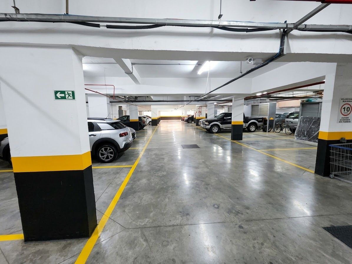A multi-level parking garage with clear directional signage, concrete flooring, and structured pillars.