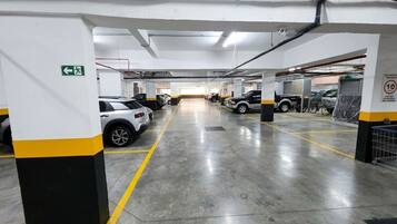 A multi-level parking garage with clear directional signage, concrete flooring, and structured pillars.