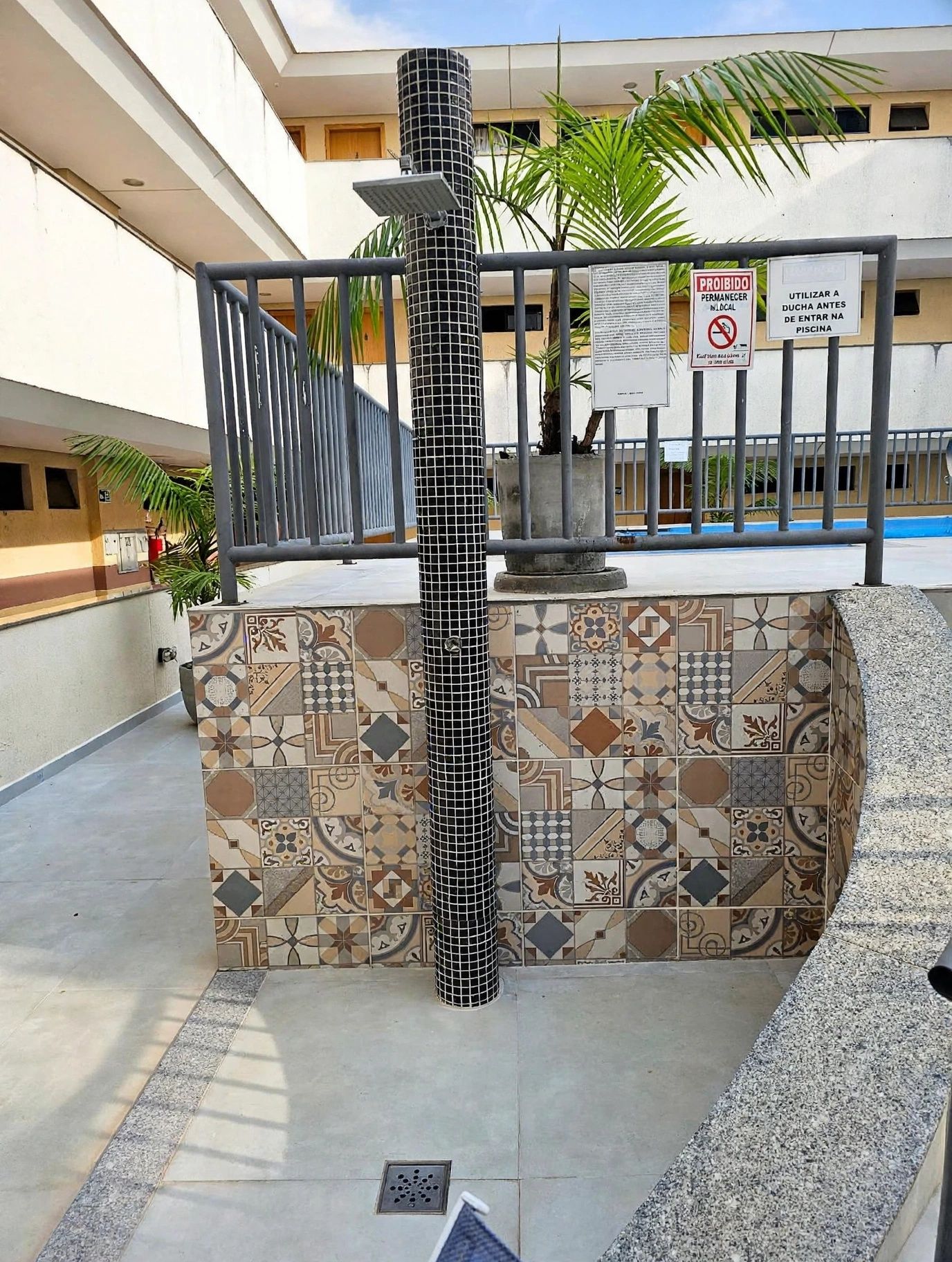 A tiled column with a metal railing and a sign prohibiting permanent parking.