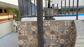 A tiled column with a metal railing and a sign prohibiting permanent parking.