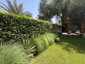 A well-maintained garden with a variety of plants, a large decorative sphere, and outdoor seating. - Villa in Marrakech, with a private pool (Marrakech)