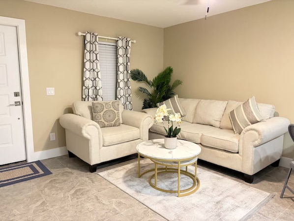 A living room with two sofas, a coffee table, and a potted plant. - Cozy 2BR/1BA house in lovely Bradenton 25 minutes from Beaches (Bradenton)